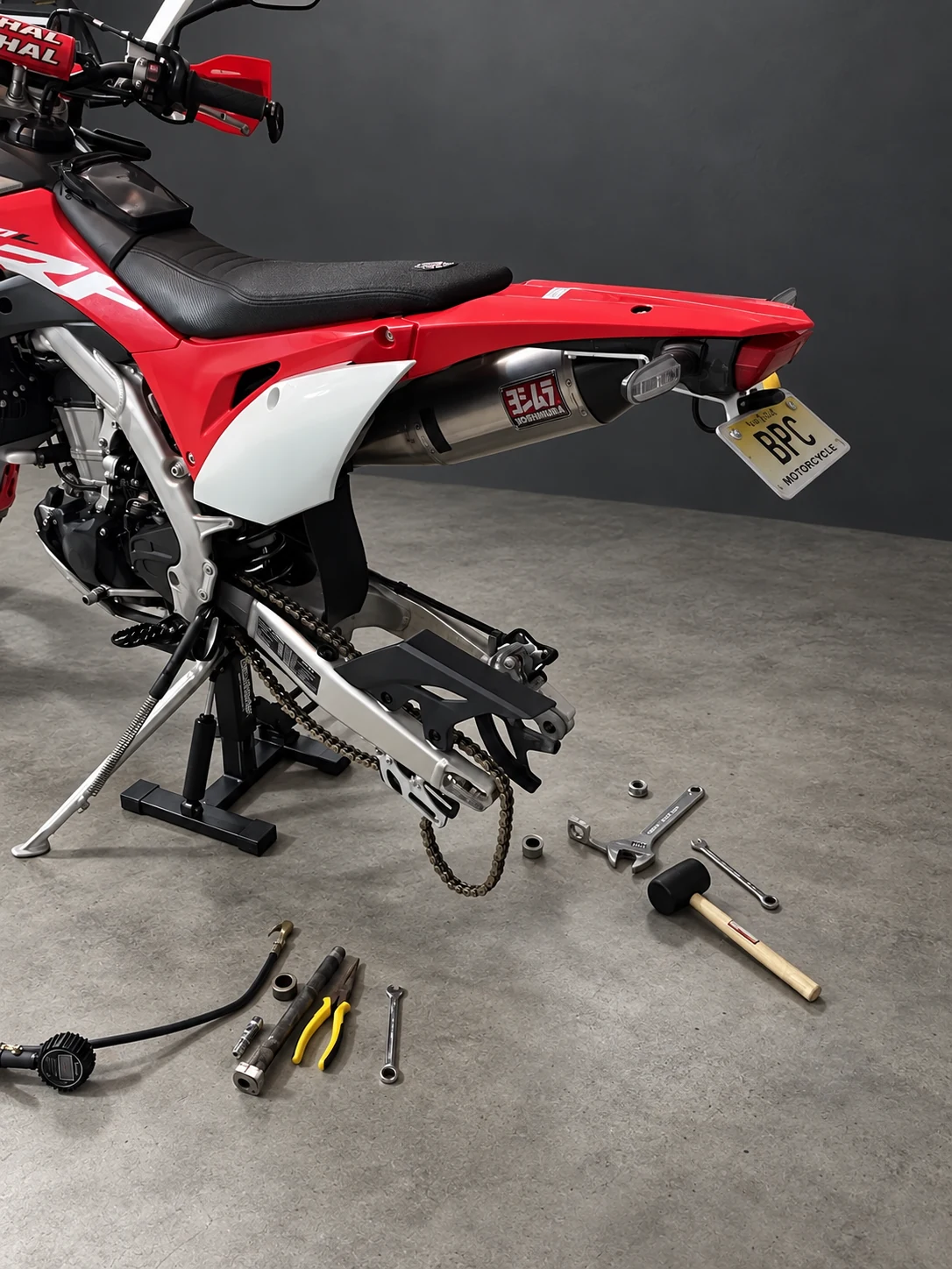 Honda CRF450L during rear-wheel service on its workshop stand